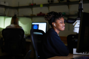 Woman looks at a computer screen in a darkened room