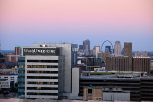 The “Super Blue Moon” rises in the night sky over the Neuroscience Research Building and downtown St. Louis skyline on August 30, 2023.