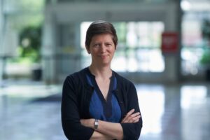 Martha Bagnall is a white woman with short brown hair standing with her arms crossed.