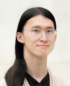 Binxu Wang has long black hair and is wearing glasses.