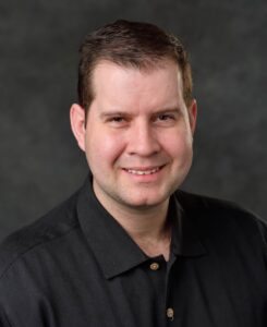 Daniel Vogt is a man with short dark hair and wearing a dark shirt.