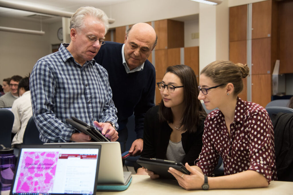 From left, Paul Bridgman, PhD, and Krikor Dikranian, MD, PhD, professors in the Department of Neuroscience at Washington University School of Medicine in St. Louis, demonstrate the histology iBook they created to medical students Caroline Min and Sarah Tepper.