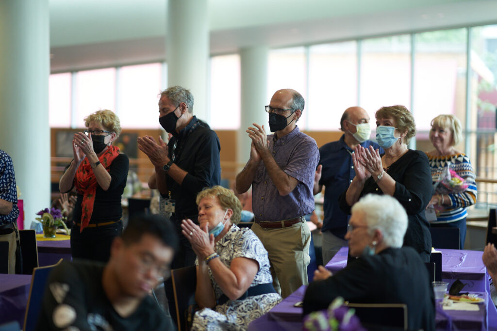 Tim Holy and Andreas Burkhalter clapping at Ann Olendorff's retirement reception